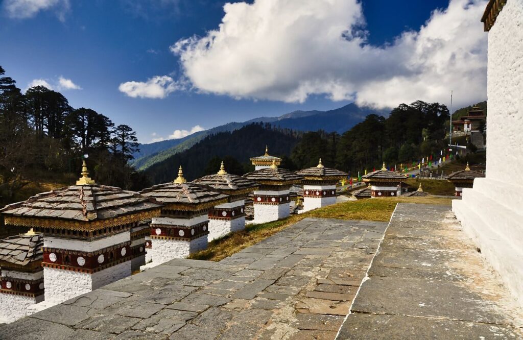 The 108 memorial chortens at Dochula pass under a blue sky