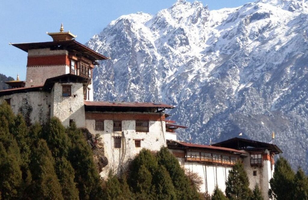 Gasa Dzong on its hillside with snow-covered peaks rising behind